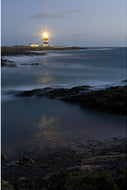Hook Lighthouse beam reflecting across calm waters at dusk, Co. Wexford — fine art landscape photograph by Peter Cox