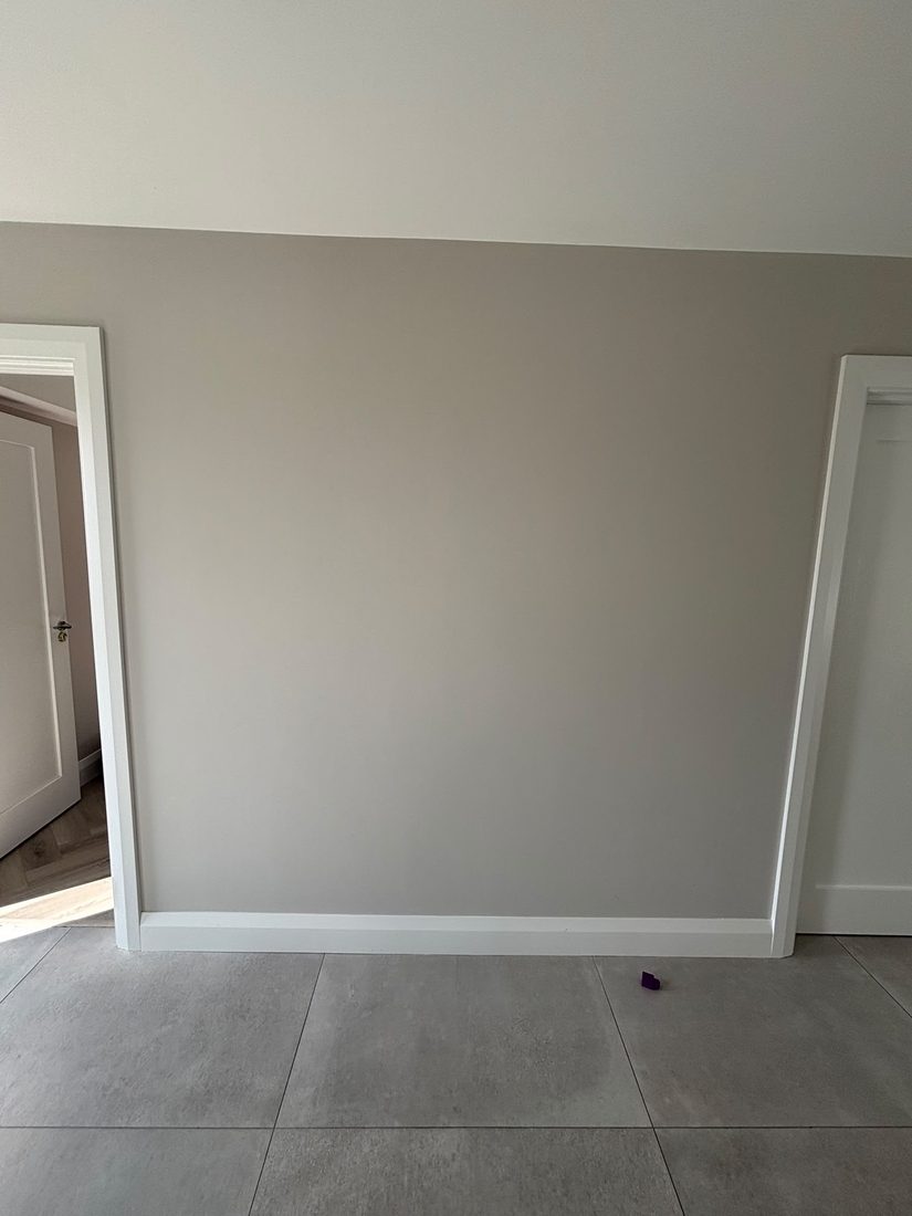 An empty landing wall between two doors, photographed by the customer before any print was added